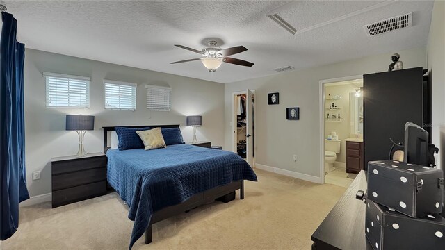 148 Whirlaway Dr, Davenport, FL 33837 - bedroom featuring light colored carpet, a walk in closet, a textured ceiling, ensuite bathroom, and a ceiling fan