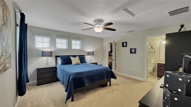 148 Whirlaway Dr, Davenport, FL 33837 - bedroom with light colored carpet, a walk in closet, ensuite bathroom, ceiling fan, and a textured ceiling