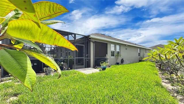 148 Whirlaway Dr, Davenport, FL 33837 - back of property with stucco siding, a lawn, and a lanai