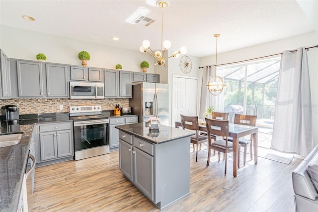 8491 Oasis Key Cv, Kissimmee, FL 34747 - kitchen with appliances with stainless steel finishes, gray cabinets, light wood-style flooring, recessed lighting, and a textured ceiling