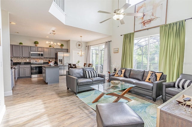 8491 Oasis Key Cv, Kissimmee, FL 34747 - living area featuring light wood-style flooring, a chandelier, a ceiling fan, a high ceiling, and recessed lighting