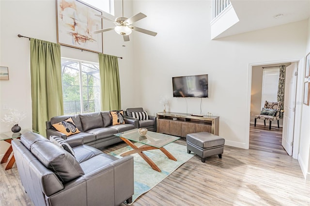 8491 Oasis Key Cv, Kissimmee, FL 34747 - living area featuring a towering ceiling, light wood-style floors, baseboards, and ceiling fan