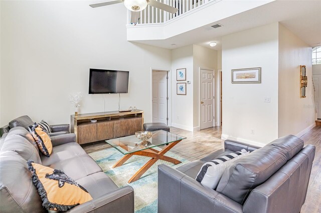 8491 Oasis Key Cv, Kissimmee, FL 34747 - living area featuring light wood-style floors, ceiling fan, baseboards, and a high ceiling