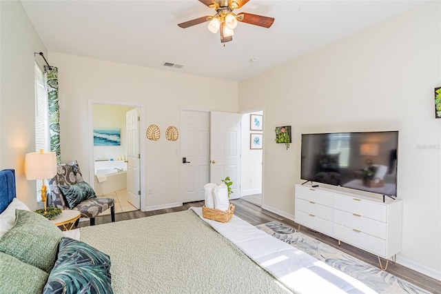 8491 Oasis Key Cv, Kissimmee, FL 34747 - bedroom featuring wood finished floors, baseboards, ensuite bath, and a ceiling fan