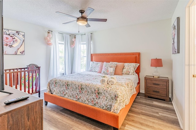 8491 Oasis Key Cv, Kissimmee, FL 34747 - bedroom featuring wood finished floors, a textured ceiling, a ceiling fan, and baseboards