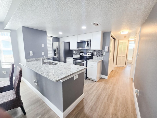2735 N Poinciana Blvd Unit 95, Kissimmee, FL 34746 - kitchen featuring appliances with stainless steel finishes, a sink, baseboards, white cabinetry, and light wood-type flooring