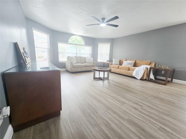 2735 N Poinciana Blvd Unit 95, Kissimmee, FL 34746 - living area with ceiling fan, baseboards, light wood finished floors, and a textured ceiling