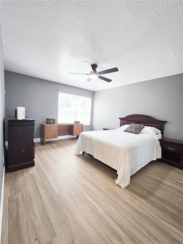 2735 N Poinciana Blvd Unit 95, Kissimmee, FL 34746 - bedroom with light wood-type flooring, a textured ceiling, and a ceiling fan