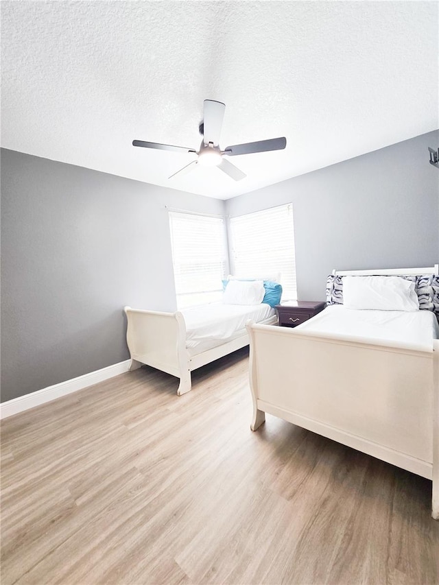 2735 N Poinciana Blvd Unit 95, Kissimmee, FL 34746 - bedroom with wood finished floors, baseboards, ceiling fan, and a textured ceiling