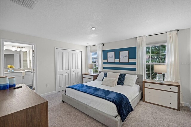 1565 Plunker Dr, Davenport, FL 33896 - carpeted bedroom with multiple windows, a closet, a textured ceiling, baseboards, and ensuite bathroom