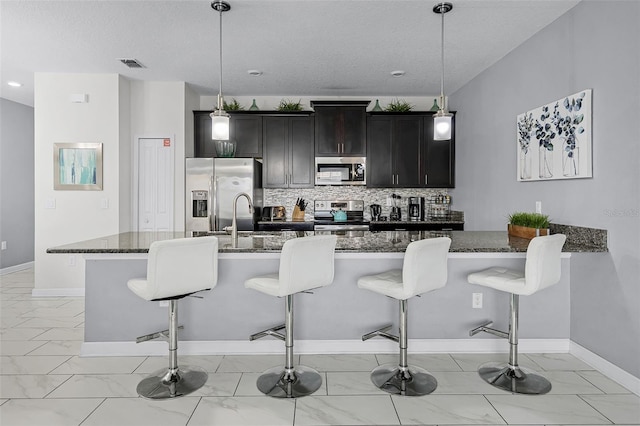 1578 Slice Way, Davenport, FL 33896 - kitchen with appliances with stainless steel finishes, light marble finish floors, a kitchen breakfast bar, backsplash, and a textured ceiling