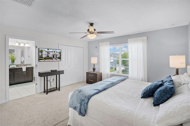 1578 Slice Way, Davenport, FL 33896 - bedroom with light carpet, a closet, a ceiling fan, connected bathroom, and a textured ceiling