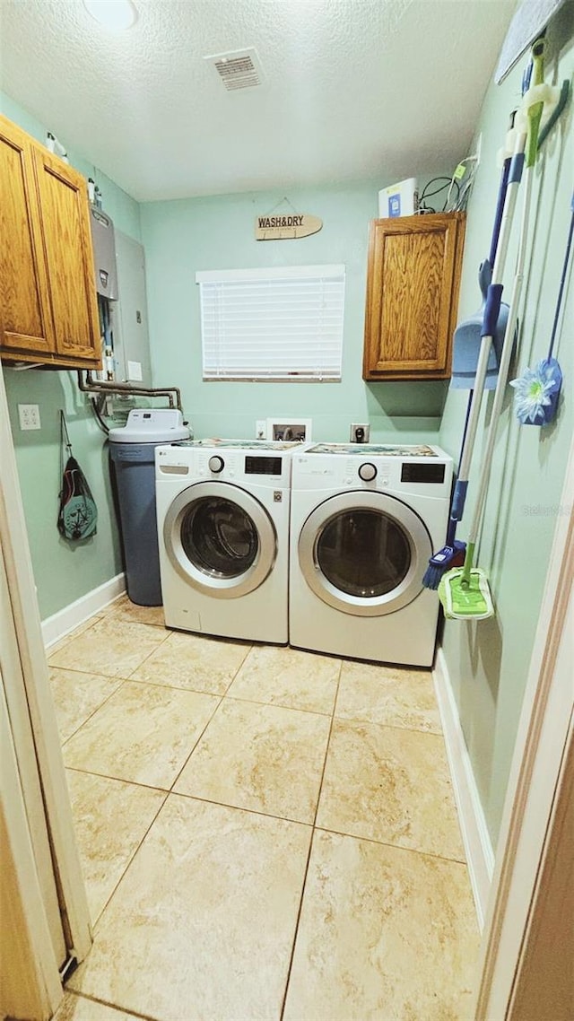 745 17th Ave, Vero Beach, FL 32962 - washroom featuring cabinet space, separate washer and dryer, a textured ceiling, and light tile patterned floors