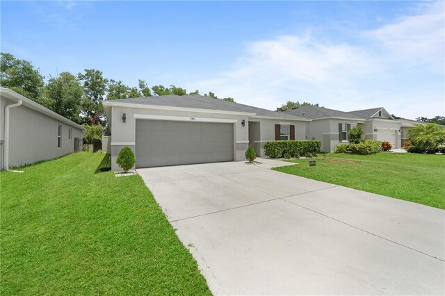 2461 Bulrush Dr, Saint Cloud, FL 34769 - view of front of property with an attached garage, concrete driveway, stucco siding, and a front yard