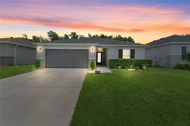 2461 Bulrush Dr, Saint Cloud, FL 34769 - view of front of home with a garage, concrete driveway, a yard, and stucco siding