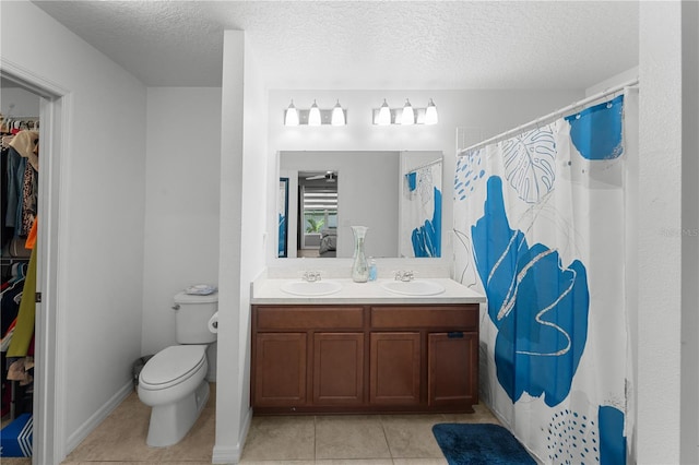 2461 Bulrush Dr, Saint Cloud, FL 34769 - bathroom featuring tile patterned flooring, a spacious closet, toilet, double vanity, and a textured ceiling