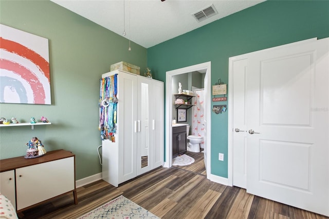 1064 Quaker Ridge Ln, Davenport, FL 33896 - bedroom with wood finished floors, baseboards, and ensuite bath