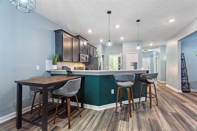 1064 Quaker Ridge Ln, Davenport, FL 33896 - kitchen with stainless steel appliances, dark wood-type flooring, baseboards, recessed lighting, and a peninsula