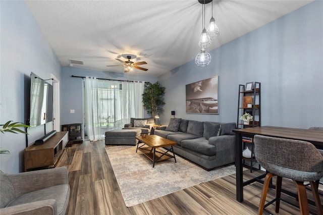 1064 Quaker Ridge Ln, Davenport, FL 33896 - living area with a wood stove, wood finished floors, and ceiling fan