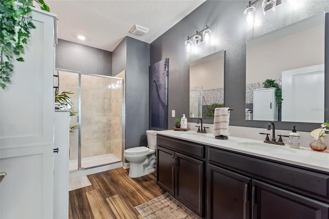 1064 Quaker Ridge Ln, Davenport, FL 33896 - bathroom with toilet, wood finished floors, double vanity, a stall shower, and a textured wall