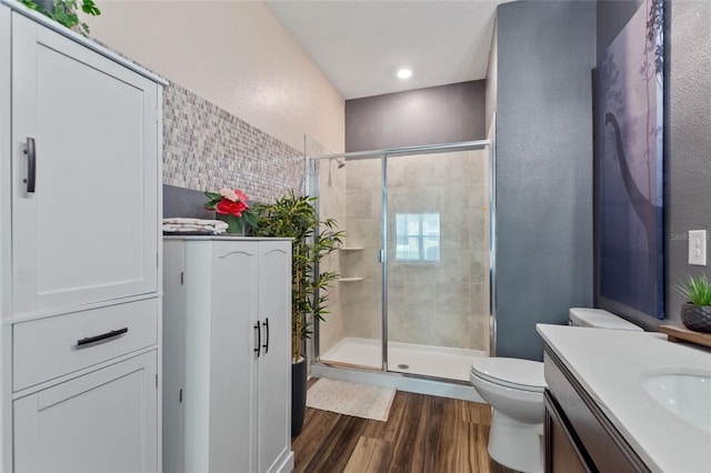 1064 Quaker Ridge Ln, Davenport, FL 33896 - bathroom featuring wood finished floors, toilet, a shower stall, vanity, and a textured wall
