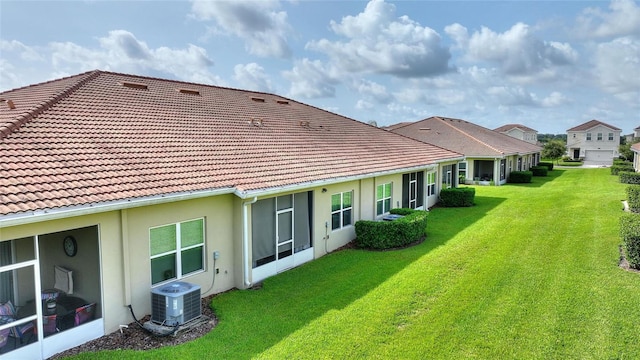 1064 Quaker Ridge Ln, Davenport, FL 33896 - rear view of property featuring central AC, stucco siding, a yard, and a tiled roof