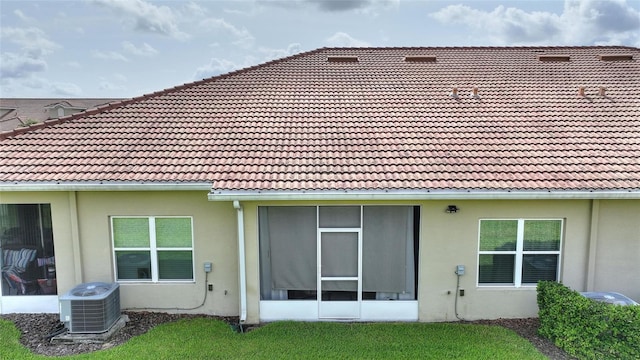 1064 Quaker Ridge Ln, Davenport, FL 33896 - back of house featuring central air condition unit, a tile roof, stucco siding, and a sunroom