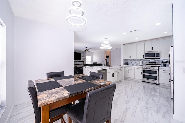2503 Calla Lily Cv, Kissimmee, FL 34758 - dining space featuring light marble finish flooring, recessed lighting, ceiling fan, and baseboards