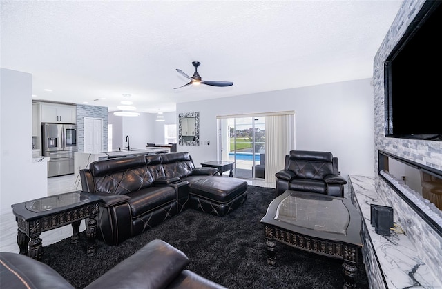 2503 Calla Lily Cv, Kissimmee, FL 34758 - living room featuring ceiling fan and a stone fireplace