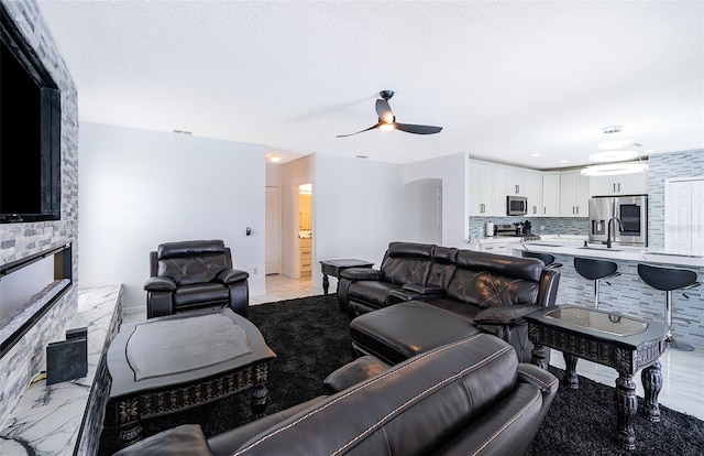 2503 Calla Lily Cv, Kissimmee, FL 34758 - living room with a ceiling fan, a fireplace, and a textured ceiling