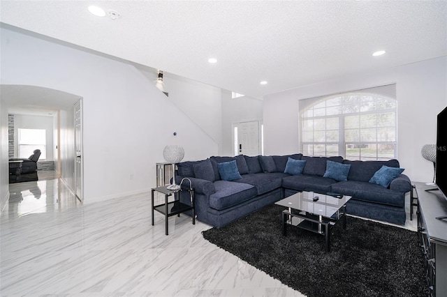 2503 Calla Lily Cv, Kissimmee, FL 34758 - living area featuring arched walkways, a textured ceiling, recessed lighting, and light marble finish floors