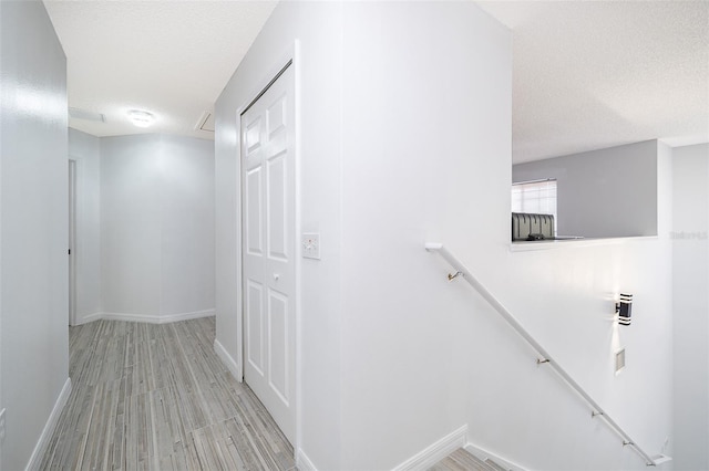 2503 Calla Lily Cv, Kissimmee, FL 34758 - hall featuring an upstairs landing, a textured ceiling, baseboards, and wood finished floors