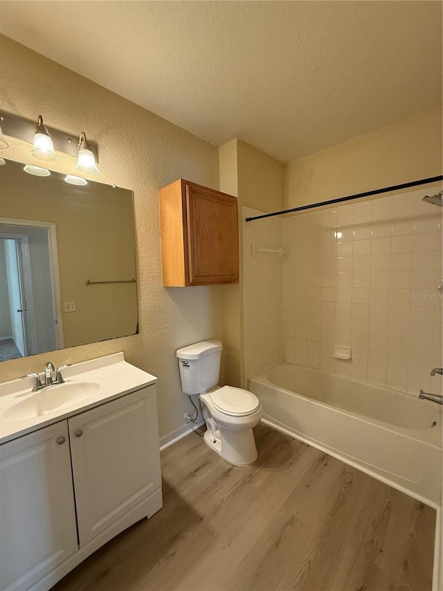 6169 Metrowest Blvd Unit 208, Orlando, FL 32835 - full bathroom featuring wood finished floors, a textured wall, a textured ceiling, vanity, and bathing tub / shower combination