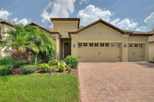 1353 Palmetto Dunes St, Davenport, FL 33836 - mediterranean / spanish-style home with stucco siding, decorative driveway, an attached garage, a tiled roof, and a front yard