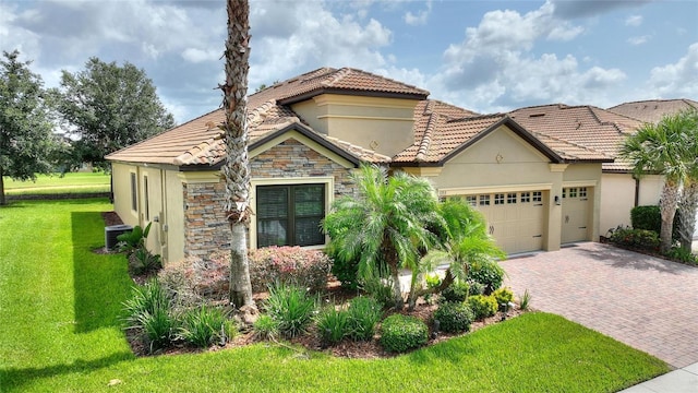 1353 Palmetto Dunes St, Davenport, FL 33836 - mediterranean / spanish home featuring a garage, stucco siding, decorative driveway, a tiled roof, and a front lawn