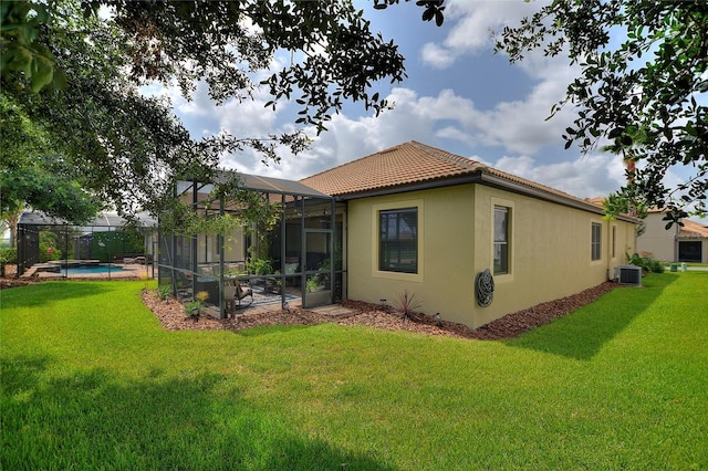 1353 Palmetto Dunes St, Davenport, FL 33836 - back of house with a tile roof, stucco siding, a lawn, and glass enclosure