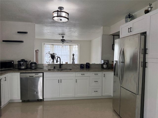 416 Sea Willow Dr, Kissimmee, FL 34743 - kitchen featuring stainless steel appliances, a ceiling fan, white cabinets, dark stone counters, and a textured ceiling