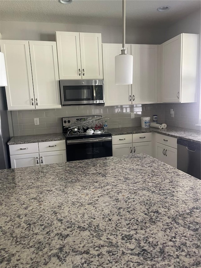 2813 Roseglen Way, Orlando, FL 32812 - kitchen with appliances with stainless steel finishes, dark stone countertops, white cabinets, and decorative backsplash