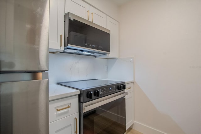4768 Tangerine Ave Unit 4768, Winter Park, FL 32792 - kitchen with appliances with stainless steel finishes, light countertops, white cabinetry, and tasteful backsplash