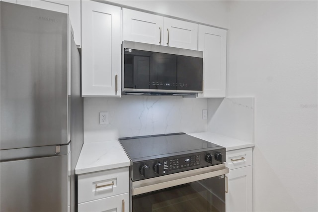 4768 Tangerine Ave Unit 4768, Winter Park, FL 32792 - kitchen featuring freestanding refrigerator, electric range oven, white cabinetry, decorative backsplash, and light stone countertops