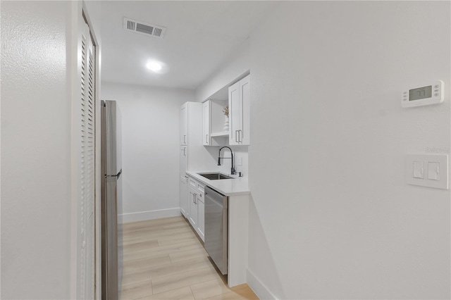 4768 Tangerine Ave Unit 4768, Winter Park, FL 32792 - kitchen with dishwasher, white cabinets, freestanding refrigerator, light countertops, and light wood finished floors