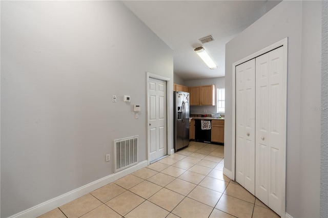 1659 Sage Creek Ct, Orlando, FL 32824 - kitchen with dishwasher, stainless steel refrigerator with ice dispenser, lofted ceiling, light tile patterned flooring, and baseboards
