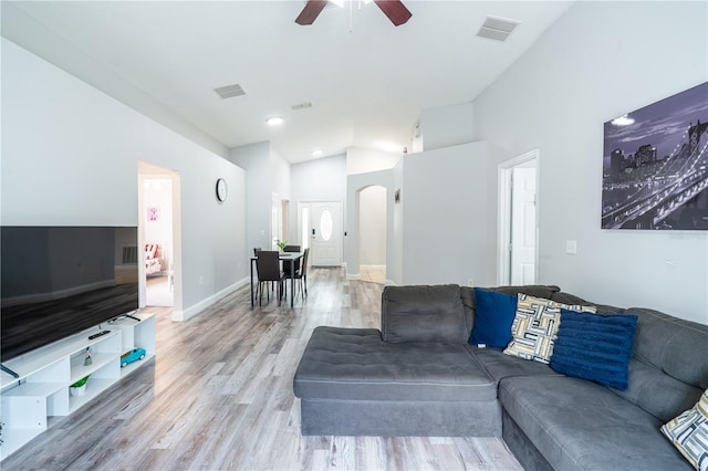 1659 Sage Creek Ct, Orlando, FL 32824 - living room featuring arched walkways, vaulted ceiling, a ceiling fan, light wood finished floors, and baseboards