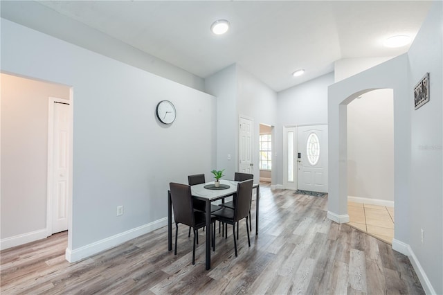 1659 Sage Creek Ct, Orlando, FL 32824 - dining room featuring arched walkways, wood finished floors, baseboards, and high vaulted ceiling