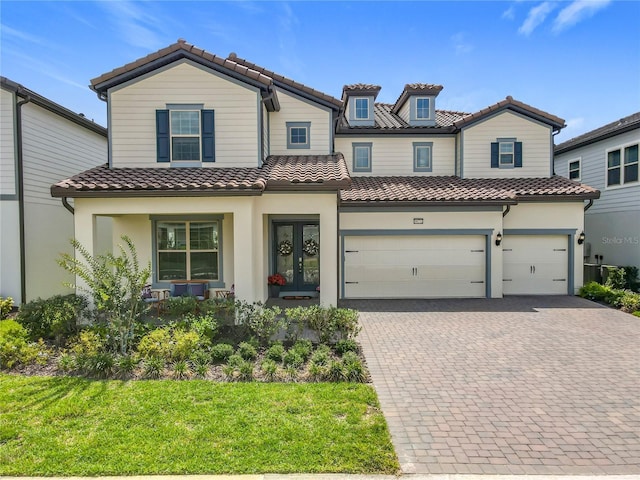 9071 Woodland Forest Rd, Orlando, FL 32836 - view of front of home featuring a tiled roof, decorative driveway, a garage, stucco siding, and a front yard