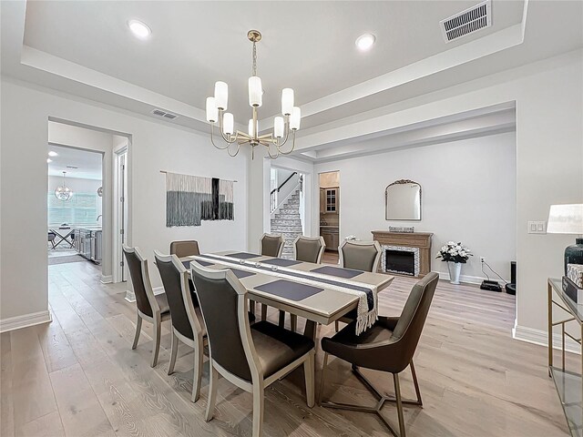 9071 Woodland Forest Rd, Orlando, FL 32836 - dining space with a chandelier, light wood-type flooring, recessed lighting, a raised ceiling, and stairs