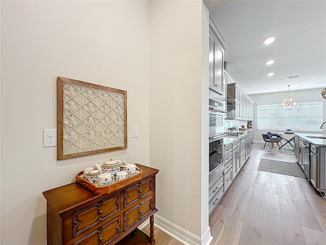 9071 Woodland Forest Rd, Orlando, FL 32836 - kitchen featuring light wood-type flooring, hanging light fixtures, recessed lighting, open shelves, and dishwasher