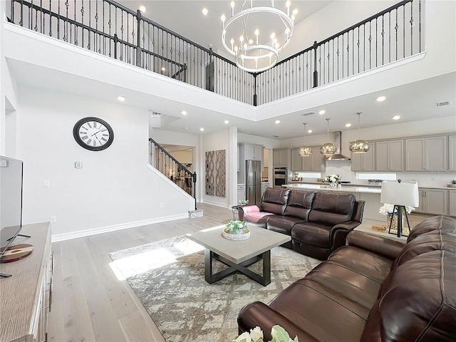 9071 Woodland Forest Rd, Orlando, FL 32836 - living room featuring a high ceiling, a chandelier, light wood-style floors, stairway, and recessed lighting