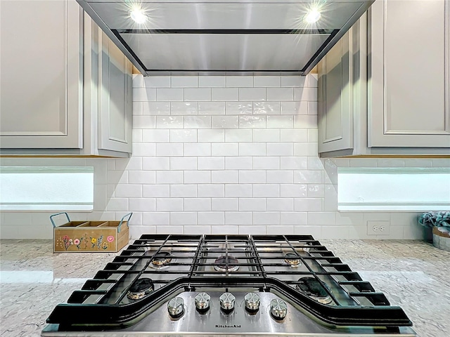 9071 Woodland Forest Rd, Orlando, FL 32836 - kitchen view of extractor fan, stainless steel gas cooktop, tasteful backsplash, and light stone countertops