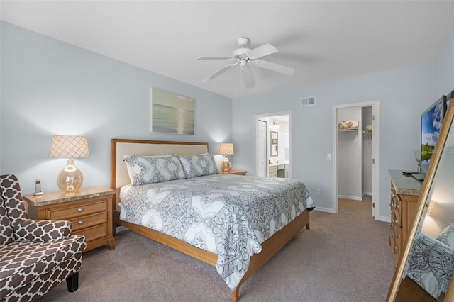 909 Troon Cir, Davenport, FL 33897 - bedroom featuring carpet floors, a walk in closet, ceiling fan, ensuite bathroom, and a closet